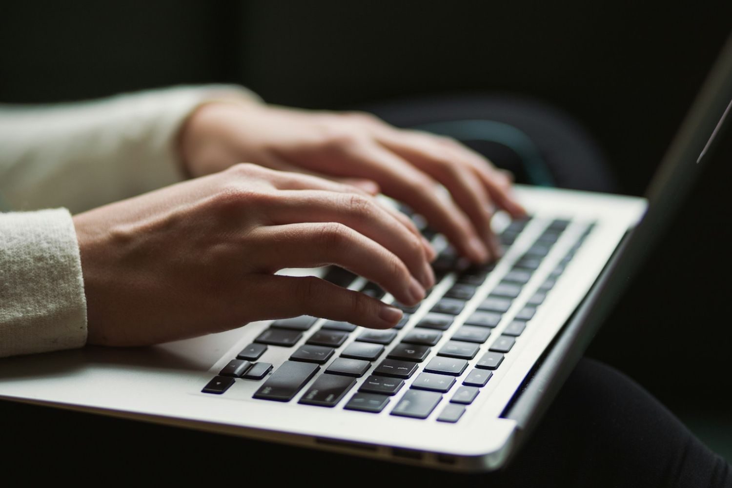 Mains tapant un texte au clavier. Photo d'illustration.